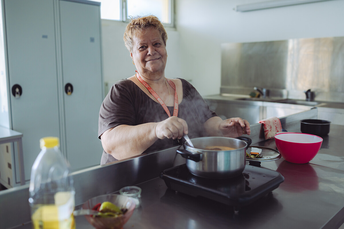 Neli Iuljeta, résidente aux Grandes Voisines, profite de la fraicheur du matin pour préparer son repas de midi dans la cuisine commune à tout l'étage.